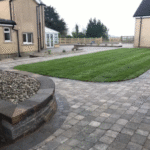 grass patch surrounded by paved concrete blocks